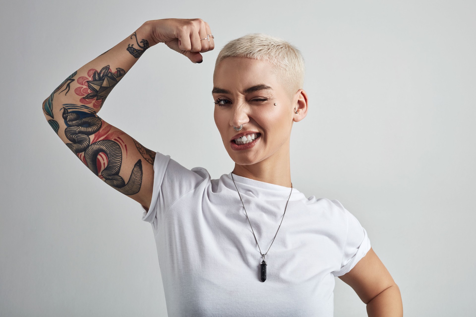 woman flexing emerging strength in white tshirt