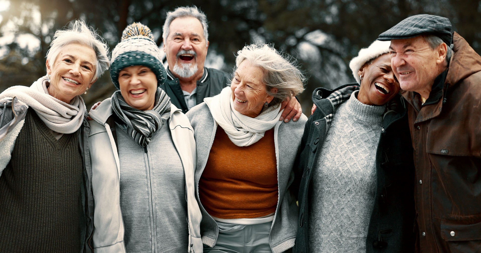 Happy, portrait and senior friends in a park while walking outdoor for fresh air together. Diversity, smile and group of elderly people in retirement taking picture and bonding in a forest in winter.